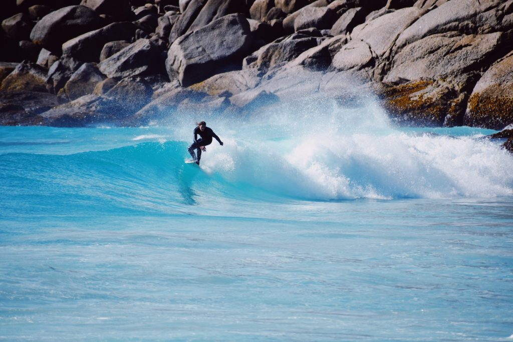 a man riding a wave on top of a surfboard